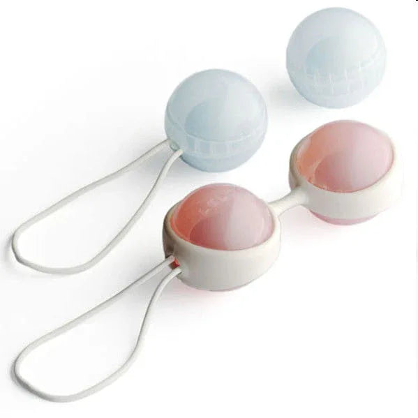 Quatre boules roses et bleues avec support et cordons de retrait sur fond blanc